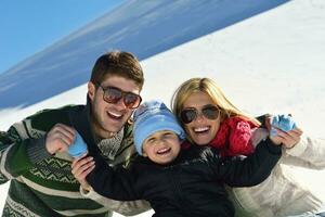 family having fun on fresh snow at winter vacation photo