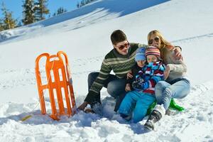 family having fun on fresh snow at winter vacation photo