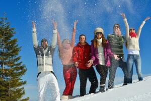 los amigos se divierten en invierno con nieve fresca foto