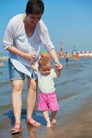 mamá y bebé en la playa se divierten foto