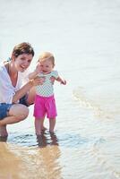 mamá y bebé en la playa se divierten foto