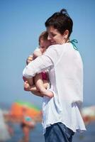 mamá y bebé en la playa se divierten foto