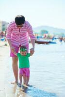 mamá y bebé en la playa se divierten foto