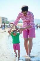 mamá y bebé en la playa se divierten foto