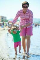 mamá y bebé en la playa se divierten foto