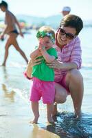 mamá y bebé en la playa se divierten foto