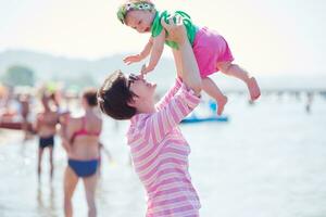 mamá y bebé en la playa se divierten foto