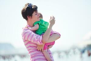 mamá y bebé en la playa se divierten foto