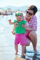 mamá y bebé en la playa se divierten foto