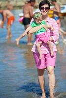 mamá y bebé en la playa se divierten foto