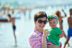 mamá y bebé en la playa se divierten foto