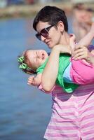 mamá y bebé en la playa se divierten foto