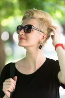 mujer joven con cabello rubio corto y gafas de sol foto