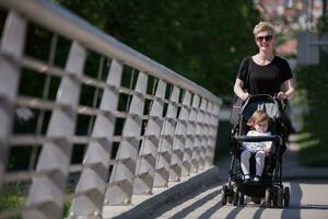 mother pushed her baby daughter in a stroller photo