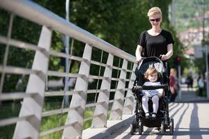 mother pushed her baby daughter in a stroller photo