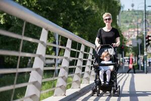 mother pushed her baby daughter in a stroller photo