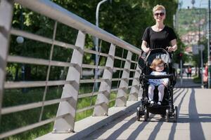 mother pushed her baby daughter in a stroller photo