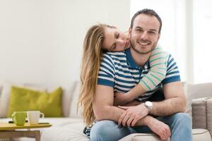 young handsome couple hugging on the sofa photo