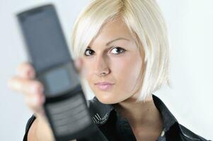 portrait of young blonde business woman holding new modern cellp photo