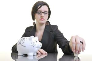 business woman putting money coins in piggy bank photo