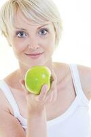 una joven feliz come manzana verde aislada en blanco foto