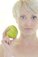 una joven feliz come manzana verde aislada en blanco foto