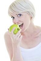 una joven feliz come manzana verde aislada en blanco foto