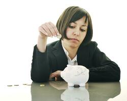 business woman putting coins money in piggy bank photo