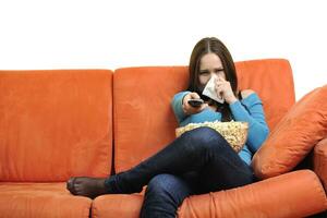 mujer joven come palomitas de maíz y ve la televisión foto