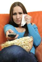 young woman eat popcorn and watching tv photo