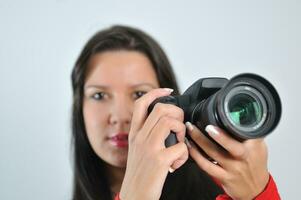 Young woman holding camera in hand taking picture isolated photo