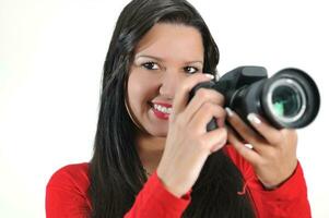 mujer joven sosteniendo una cámara en la mano tomando una foto aislada