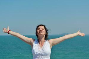 mujer joven feliz con los brazos extendidos al cielo foto