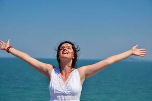 young woman with spreading arms to sky photo