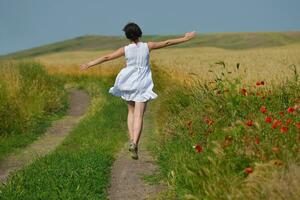 young woman in wheat field at summer photo