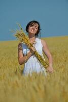 mujer joven en campo de trigo en verano foto