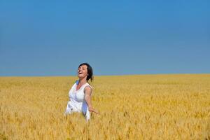 young woman in wheat field at summer photo