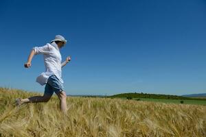 mujer joven en campo de trigo en verano foto