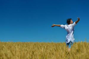 mujer joven en campo de trigo en verano foto