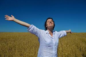 young woman in wheat field at summer photo