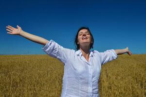 young woman in wheat field at summer photo