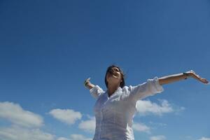 mujer joven feliz con los brazos extendidos al cielo foto