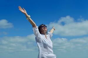 young woman with spreading arms to sky photo