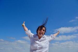 young woman with spreading arms to sky photo