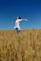 young woman in wheat field at summer photo