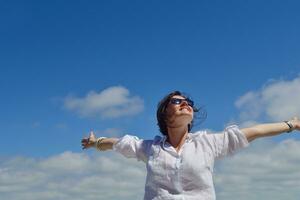 young woman with spreading arms to sky photo