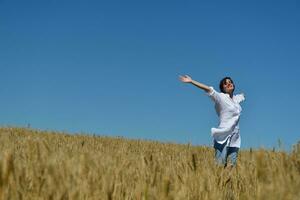 young woman in wheat field at summer photo