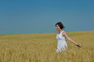 mujer joven en campo de trigo en verano foto