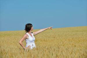 mujer joven en campo de trigo en verano foto