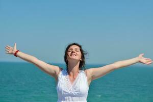 young woman with spreading arms to sky photo